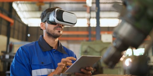 Engineer wearing virtual reality headset standing in the manufacturing factory. Blogpost about using AR in Innovation.