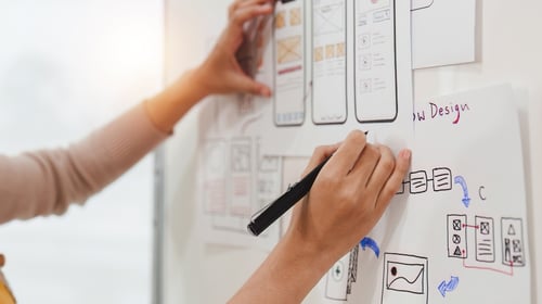 Close up UX developer and UI designer brainstorming interface wireframe design. Creative digital development agency.