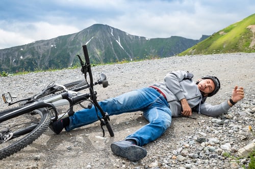Person lying on the ground after falling of his bicycle. Blogpost about using AI to save lives.