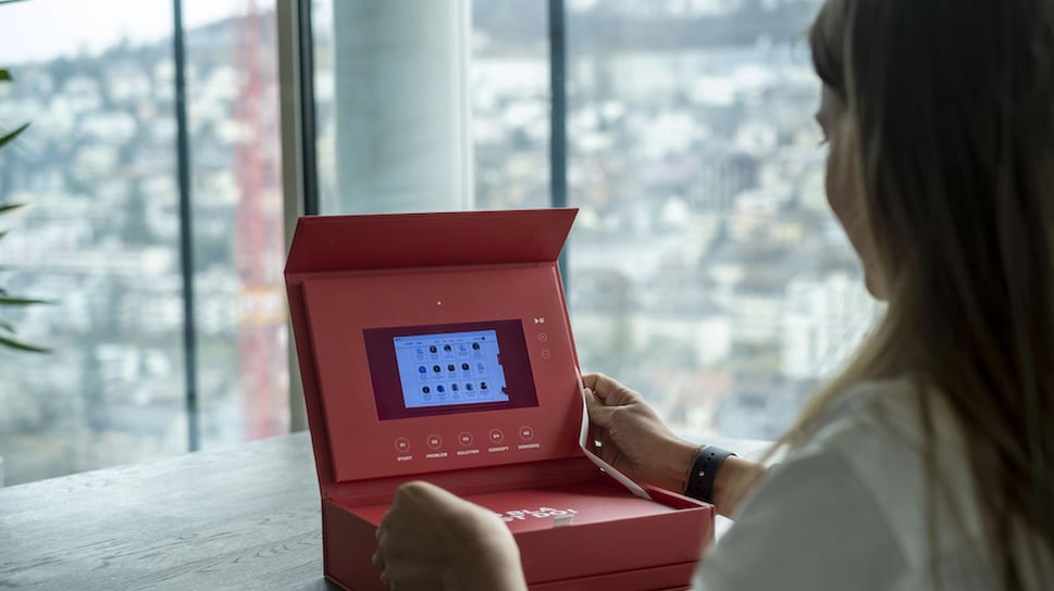 Person sitting in front of an open KICKBOX toolbox, looking at at the screen in the toolbox.