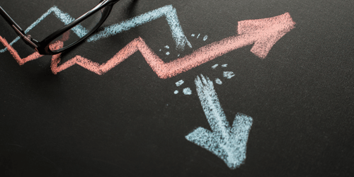 Two arrows drawn on a blackboard in blue and red. Blogpost about disruptive and sustaining innovation.
