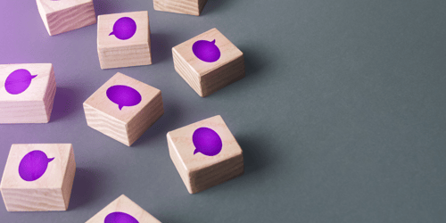 Wooden blocks with purple speech-bubbles on them.