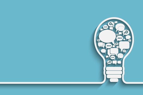 A light bulb filled with communication bubbles representing communication breaking down barriers to innovation