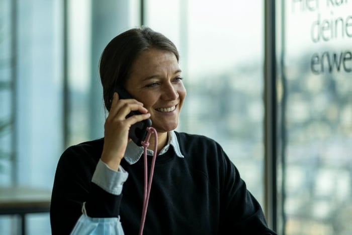 Person talking over the phone and smiling. 