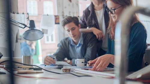 Group of young male and female designers working on a project in the office.