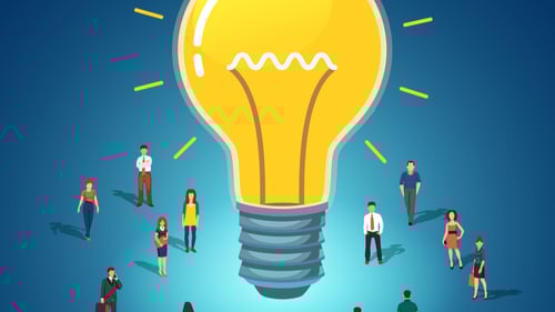 employees bask in the glow of a gigantic lightbulb to represent a successful intrapreneurship program.